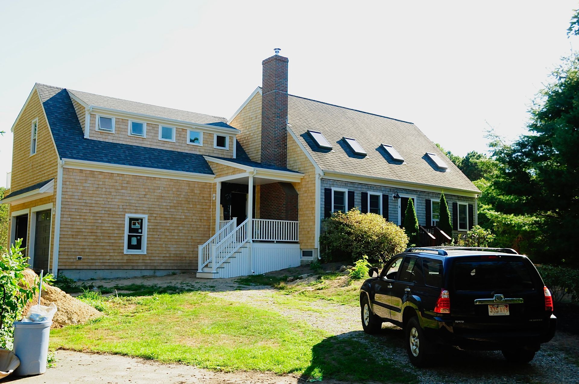 Cape Cod home with a new cedar-shingled two-story addition and front porch